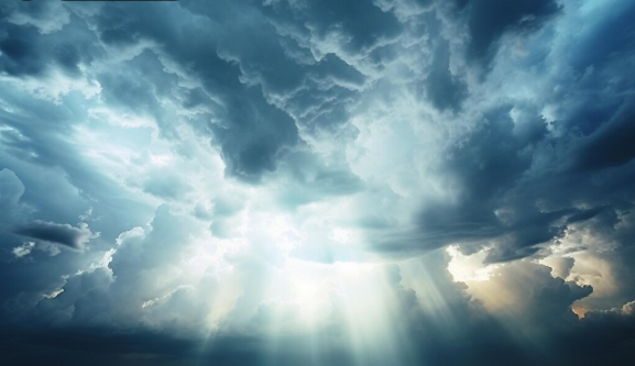 Dark storm clouds parting to reveal blue sky and sunlight